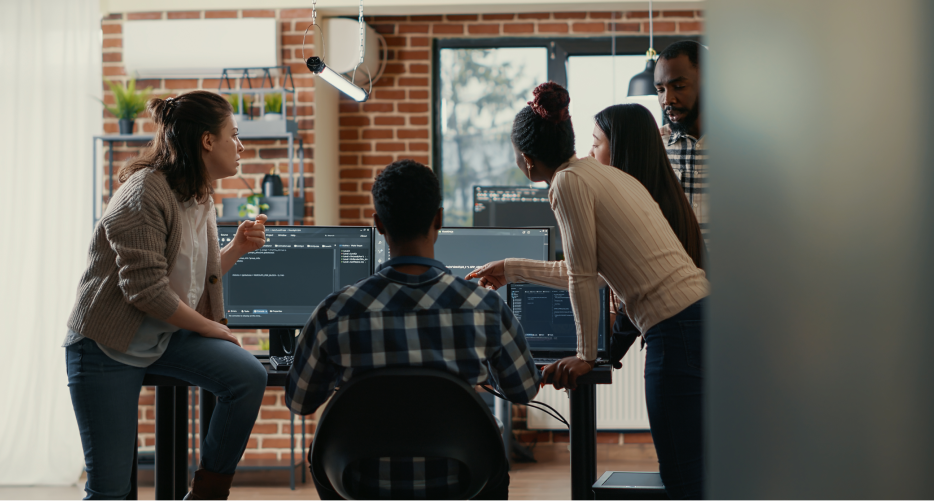 Software development team working together viewing computer screen